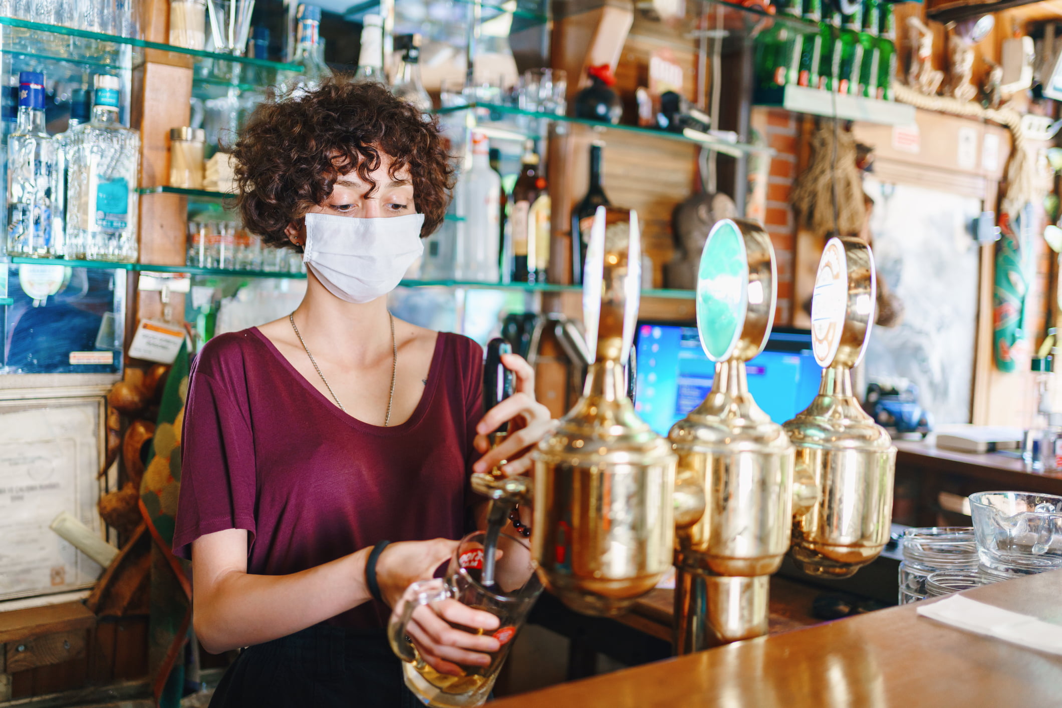 masked bartender filling beer