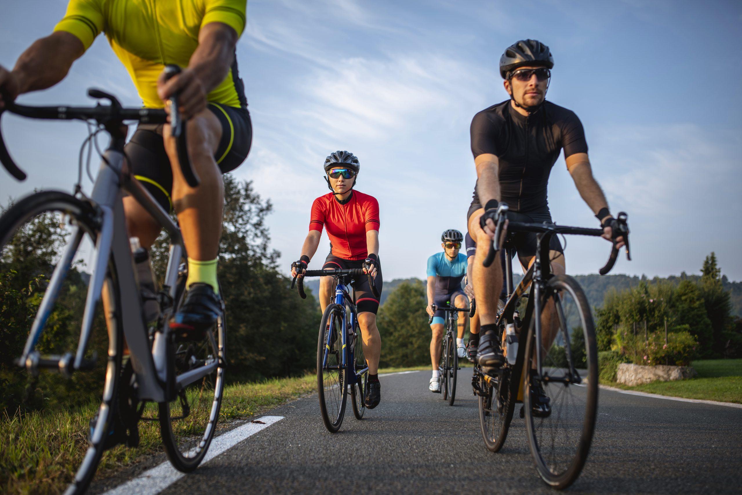Group of Fit Cyclists Riding Mountain Road in Morning